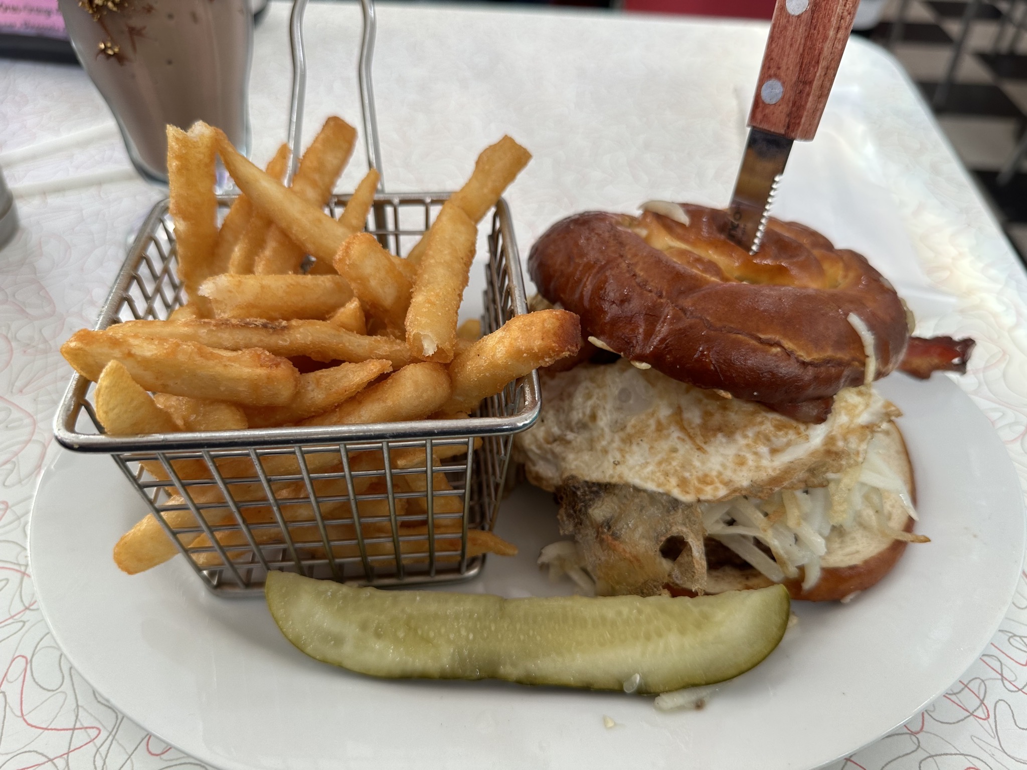 Fries and burger with bacon, egg, hash browns