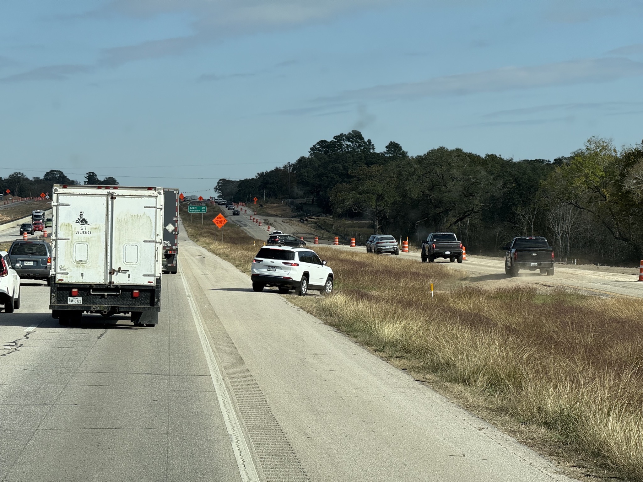Several vehicles cutting across from the freeway to a frontage road to avoid traffic