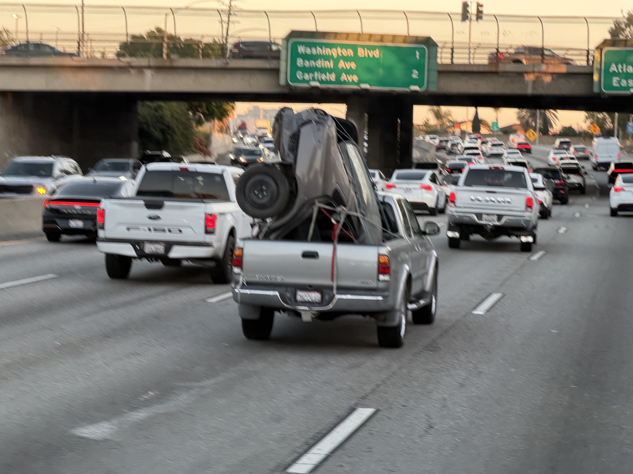 A pickup carrying half a car