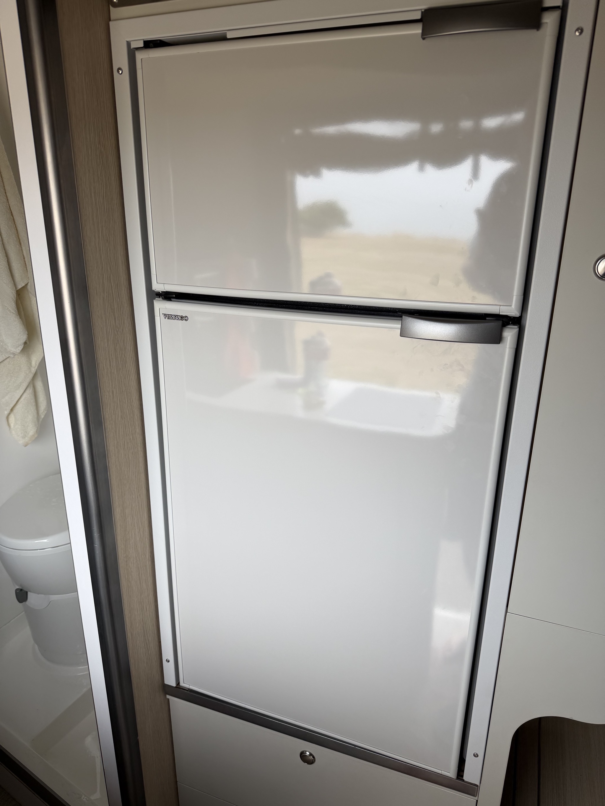 Opposite the kitchen sink, the freezer and fridge