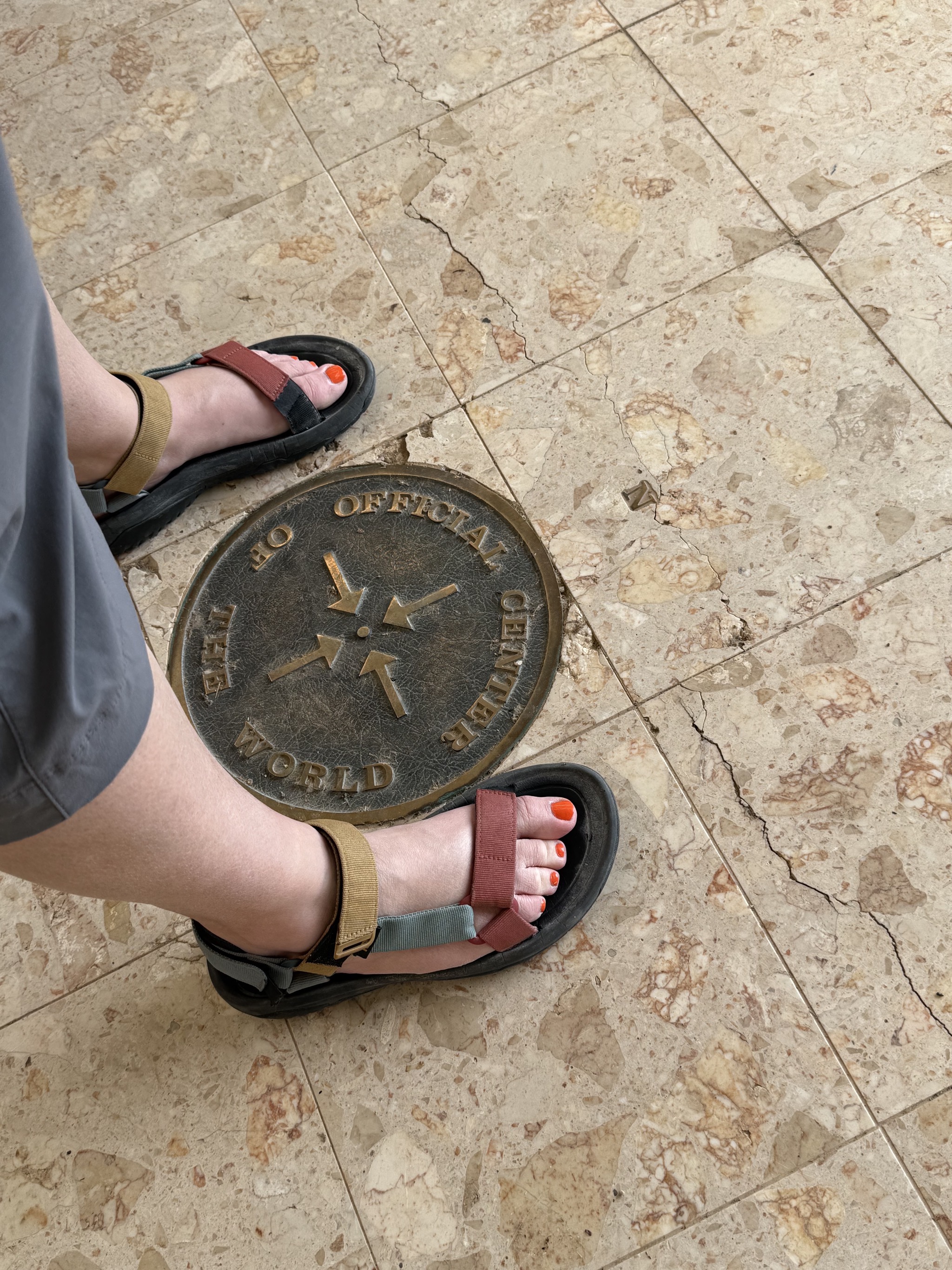 Jenn standing astride the Center of the World